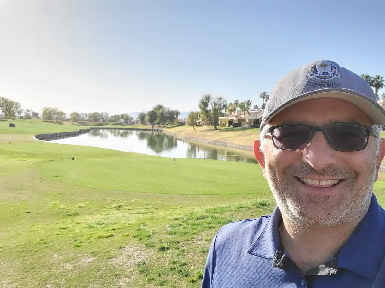 Jon Perry on a sunny morning at PGA West, with a lake behind him